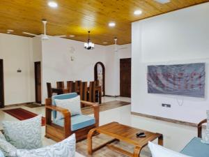 a living room with chairs and a table at Scenic Lanka rooms in Dehiwala