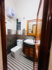 a bathroom with a toilet and a sink and a mirror at Scenic Lanka rooms in Dehiwala +32 photos
