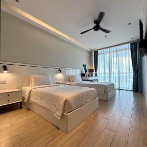 a bedroom with two beds and a ceiling fan at Grace Samudera Hotel in Semporna