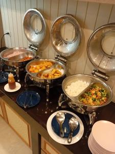 a buffet with four pans of food on a counter at Hotel De Sripoom in Chiang Mai