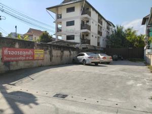 a parking lot with two cars parked in front of a building at Hotel De Sripoom in Chiang Mai +179 photos