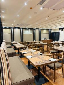 a dining room with wooden tables and chairs at Hotel Imperial Plaza Asansol in Āsansol