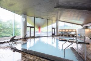 a large swimming pool in a building with windows at Hotel Kanronomori in Niseko