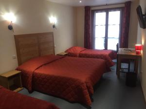 um quarto de hotel com três camas e uma janela em Le Bilboquet em Le Puy-en-Velay