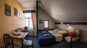 1 dormitorio con 1 cama, mesa y sillas en Penzion Bazalka, en Jablonec nad Nisou