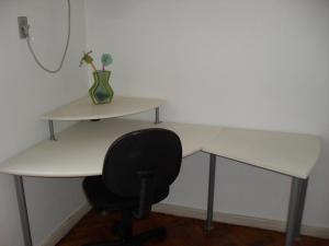 un escritorio con una silla y un jarrón con flores. en Brazil Cozy and Comfortable, en Río de Janeiro