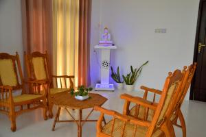a room with chairs and a table and a statue at Horton Grand Boralanda in Haputale