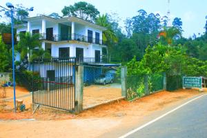 a house on the side of a road with a fence at Horton Grand Boralanda in Haputale