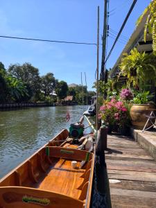 a wooden boat is docked next to a dock at นำสมัย สุขใจ สนามชัย in Bangkok +13 photos