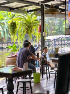 a man and a child sitting at a table in a restaurant at นำสมัย สุขใจ สนามชัย in Bangkok