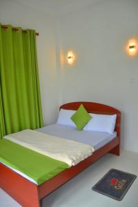 a bedroom with a bed with a green curtain at Horton Grand Boralanda in Haputale