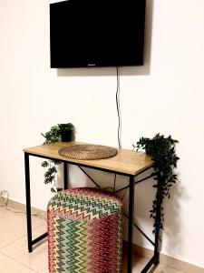 a table with a television on a wall with a chair at אמדר בעתיקה in Beer Sheva
