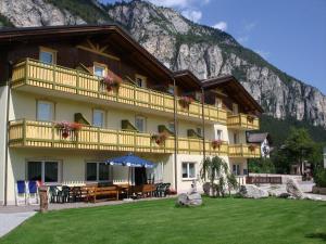 a large building with a mountain in the background at Hotel Garni Relax in Fai della Paganella