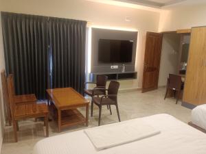 a hotel room with a living and dining room at VGN Convention Centre in Vāniyambādi