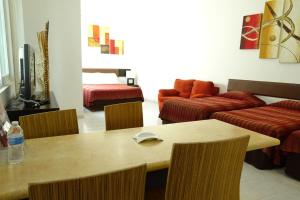 a living room with a table and a couch at Aparthotel Siete 32 in Mérida