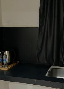 a counter with two bottles of water and a sink at Temin Roomstay in Pulau Langkawi