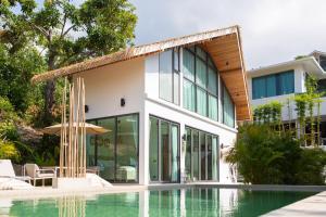 a house with a swimming pool in front of a house at Siam Mila Villas in Srithanu