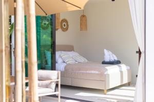 a bedroom with a bed and a chair at Siam Mila Villas in Srithanu +55 photos