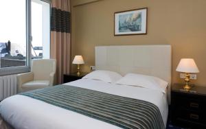 a hotel room with a bed and a window at Hotel Aguado in Dieppe