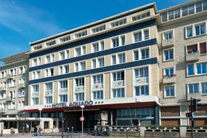 a large building on the corner of a street at Hotel Aguado in Dieppe