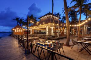 a restaurant on the beach at night with tables and chairs at MGM Beach Resorts East Coast Road in Chennai