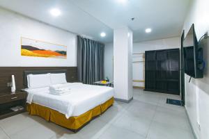 a hotel room with a bed and a television at Luna Hotel Pasay in Manila