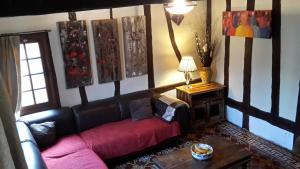 a living room with a couch and paintings on the wall at Les Hirondelles in Lyons-la-Forêt