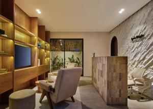 a living room with a chair and a television at Lyvin Bingin Villas in Uluwatu
