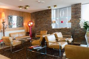 a waiting room with chairs and a brick wall at Hotel Aguado in Dieppe