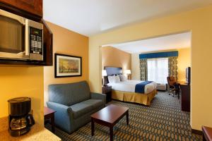 ein Hotelzimmer mit einem Bett und einem Stuhl in der Unterkunft Holiday Inn Express - Andalusia by IHG in Andalusia