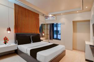 a bedroom with a bed and a window and a television at Townhouse Oak Gravity Inn in Pune