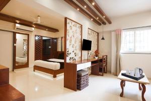 a bedroom with a bed and a desk with a television at Townhouse Oak Gravity Inn in Pune