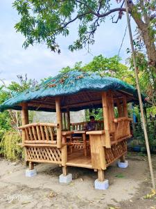 a man sitting in a wooden gazebo at Duplex A- Seaside Haven Transient Inn at Caba, La Union in Caba