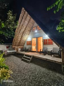 a building with a porch with benches and a tent at Duplex A- Seaside Haven Transient Inn at Caba, La Union in Caba