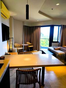 a living room with a large wooden table and chairs at ReLuxe マリン Condo in Maribago