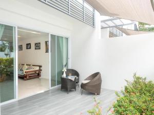 a patio with wicker chairs and a couch at Townhouse Six9 The Pool Residence in Koh Samui +17 photos