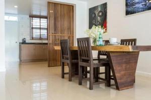 a dining room with a wooden table and chairs at Townhouse Six9 The Pool Residence in Koh Samui