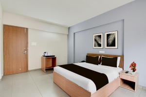 a bedroom with a large bed in a room at Super Collection O Katraj Bus Stop Formerly Indu Ville in Māngvādi