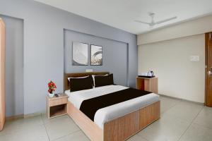 a bedroom with a large bed in a room at Super Collection O Katraj Bus Stop Formerly Indu Ville in Māngvādi