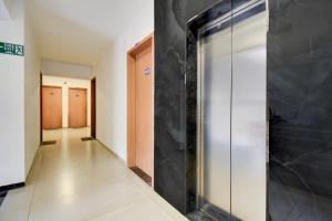 a hallway with a glass door in a building at Super Collection O Katraj Bus Stop Formerly Indu Ville in Māngvādi