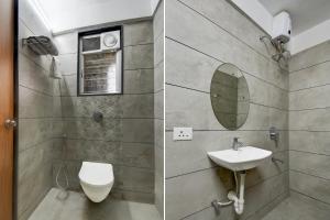a bathroom with a sink and a toilet and a mirror at Super Collection O Katraj Bus Stop Formerly Indu Ville in Māngvādi