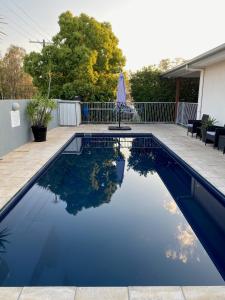 a swimming pool with blue water in a backyard at Chinchilla Motor Inn in Chinchilla