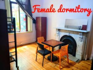 a room with a table and chairs and a fireplace at Bozo backpacker in Melbourne