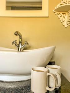 two cups of coffee on a counter next to a sink at Magoebaskloof Getaway in Magoebaskloof