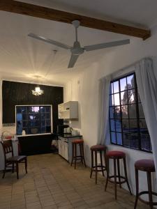 a kitchen with bar stools and a ceiling fan at The Barn, at Glenora Avenue in Somerset West
