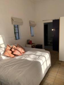 a bedroom with a bed with two pillows on it at The Barn, at Glenora Avenue in Somerset West