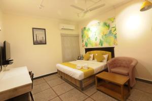 a hotel room with a bed and a chair at Sun Stayz Inn T - Nagar Chennai in Chennai