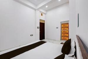 a white room with a bed and a door at SPOT ON Galaxy Hotal in Prayagraj