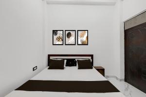 a bedroom with a bed with four pictures on the wall at SPOT ON Galaxy Hotal in Prayagraj +42 photos