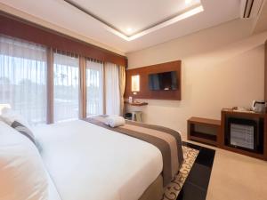 a hotel room with a bed and a television at Airindah Villa in Gili Islands +12 photos